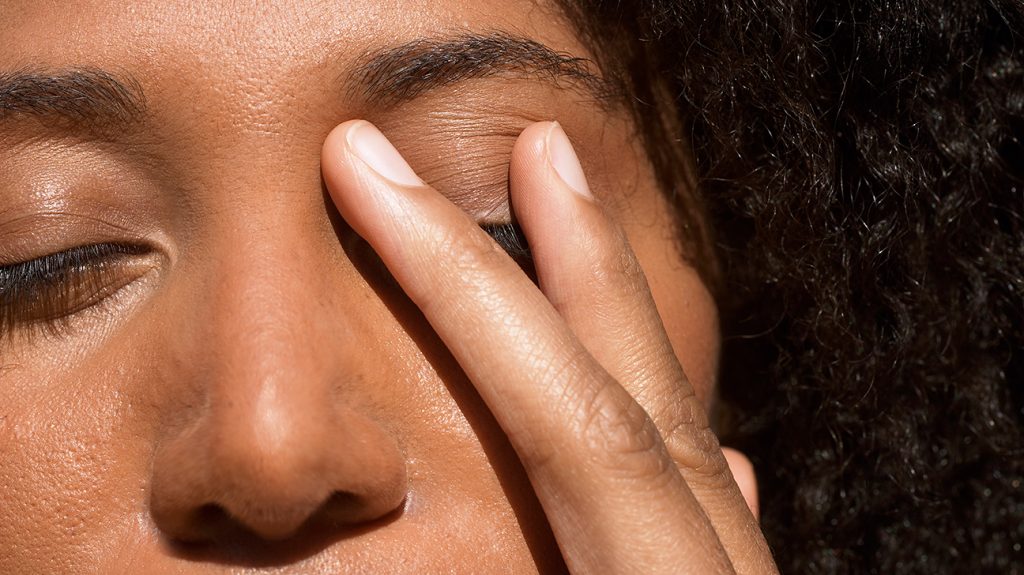 woman touching her eyes in eye clinic in Abuja